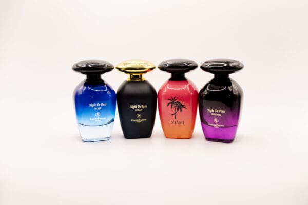 Four colorful perfume bottles on white background.